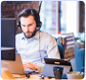 image d'un homme sur son pc avec un casque sur la tête