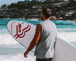 homme à la plage avec planche de surf
